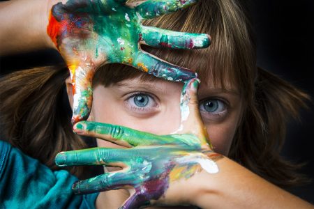 Flicka med målarfärg på händerna
