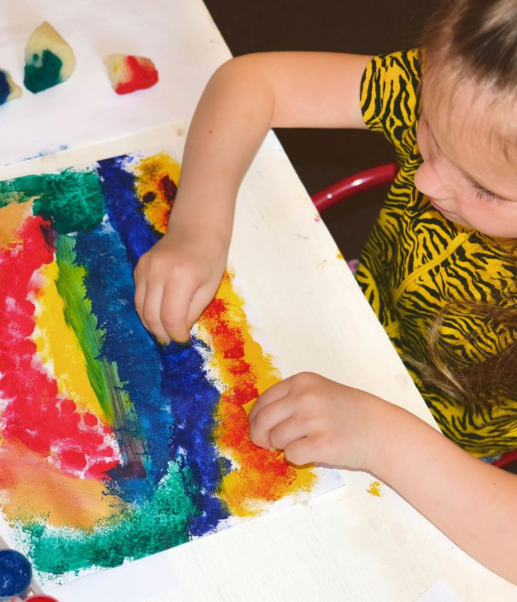 Barn som målar med vattenfärger på ett papper