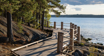 Bild på Artipelags strandpromenad i lärkträ i kvällssolen.