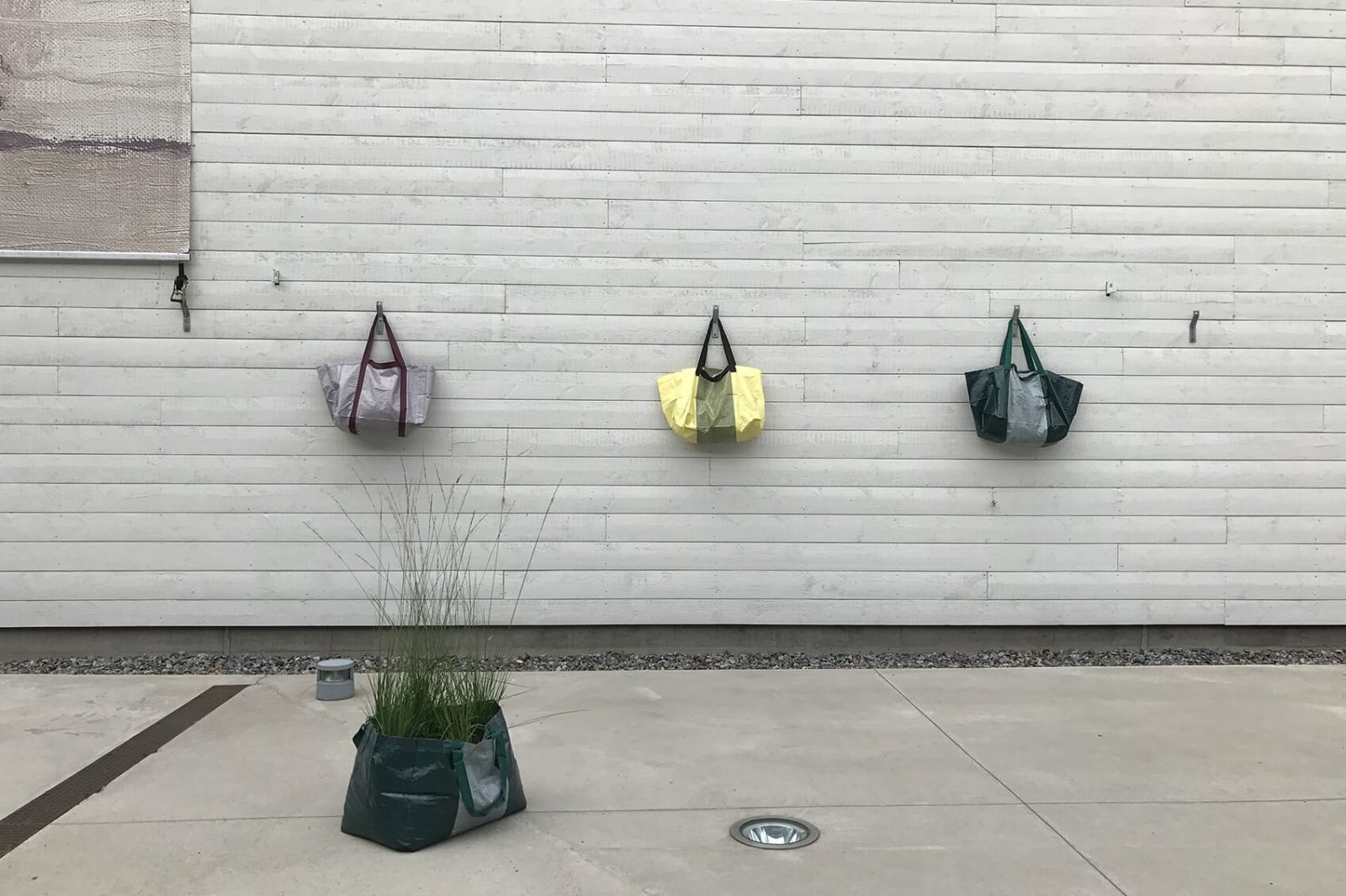 Väskor som hänger på entrégårdens vägg
