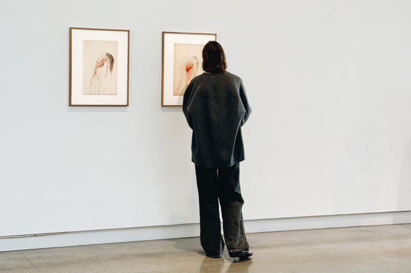Kvinna tittar på konst i Artipelags konsthall