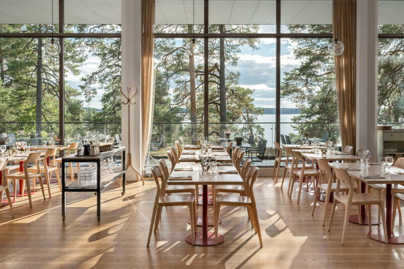 Uppdukade långbord i Artipelag Restaurang med utsikt över Baggensfjärden.
