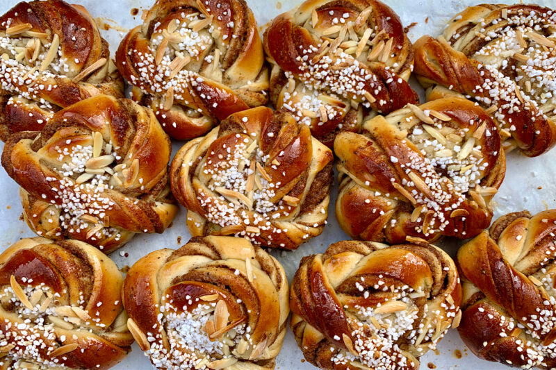 En plåt med nygräddade kanelbullar.