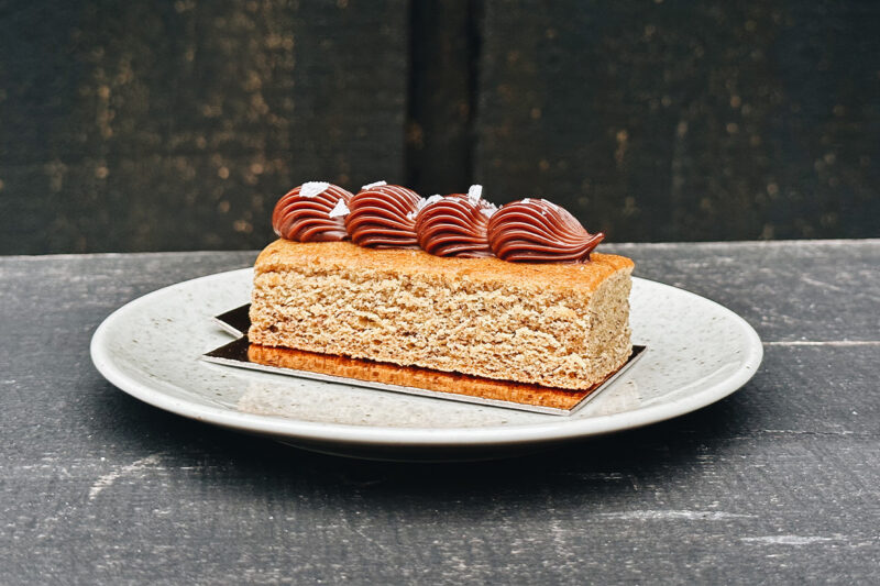 Bild på en kaka från sidan med chokladganache spritsad ovanpå.