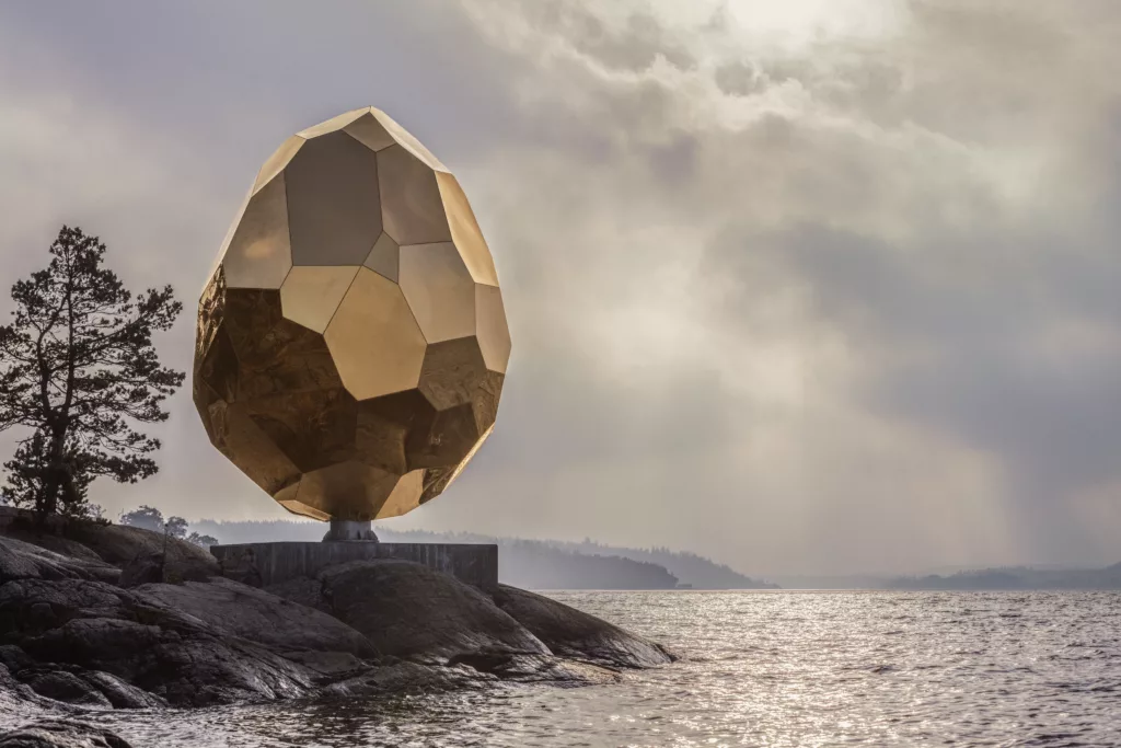 En bild på Solar egg, en skulptur som står på klipporna vid vattnet, vid Artipelag.