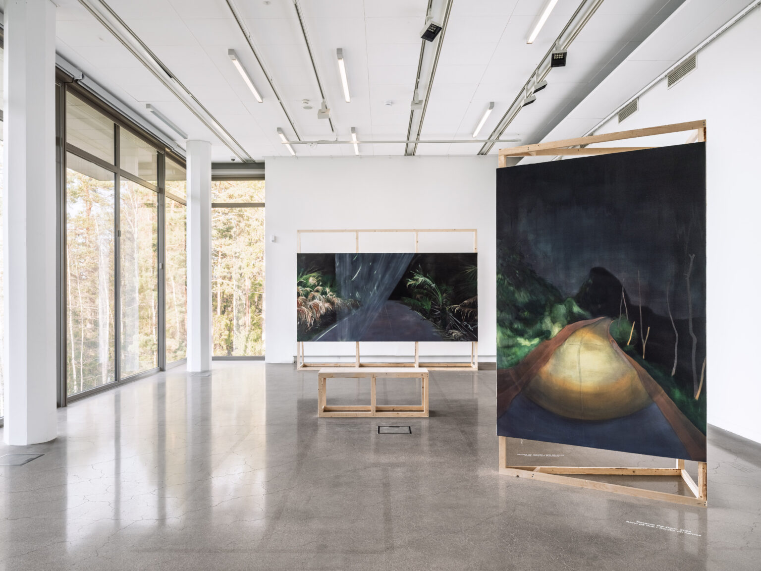Utställningsvy med målade verk i en konsthall.