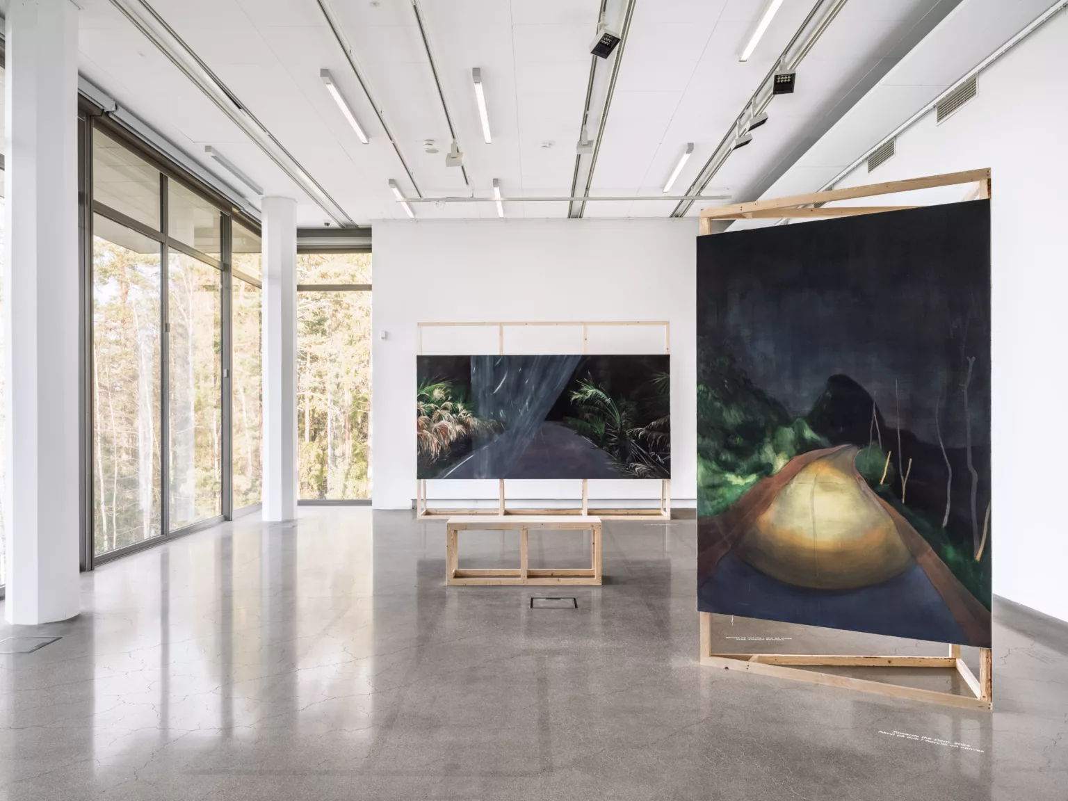 Utställningsvy med målade verk i en konsthall.