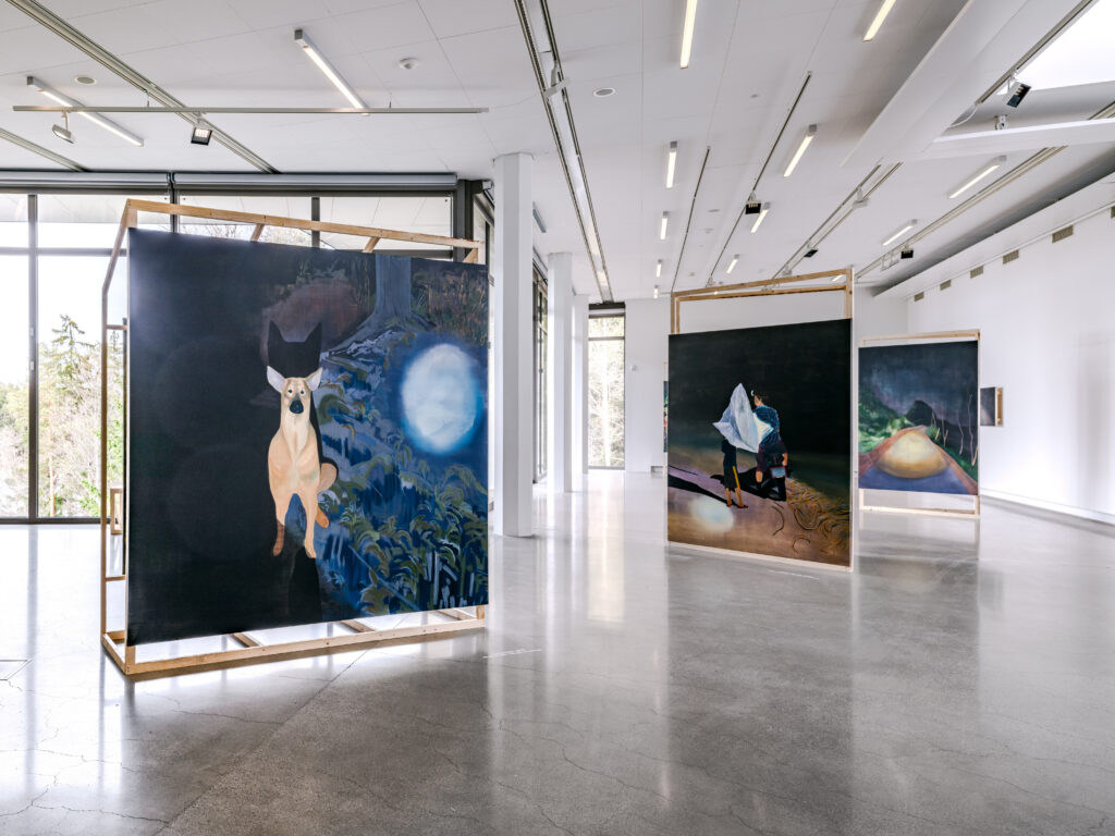 Utställningsvy med målade verk i en konsthall.