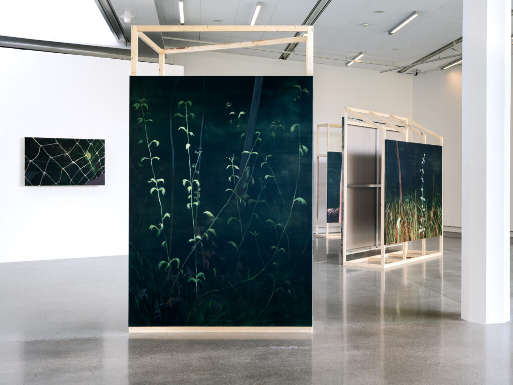 Utställningsvy med målade verk i en konsthall.