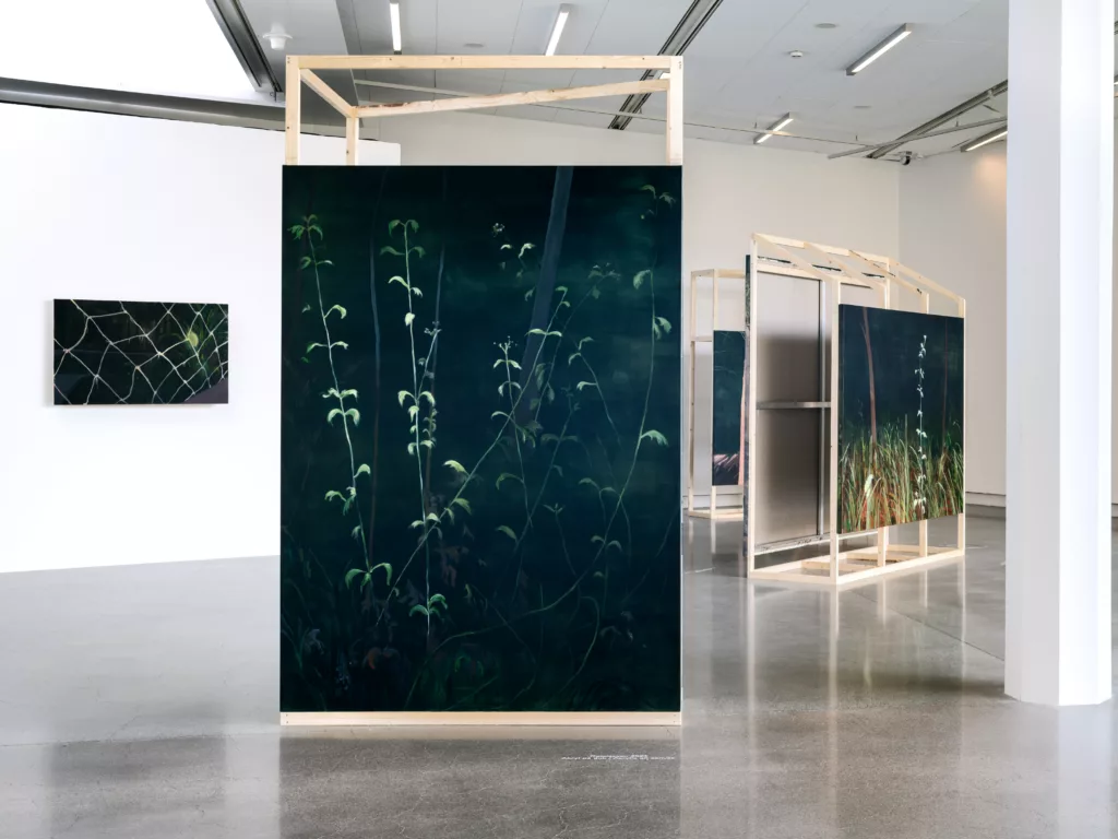 Utställningsvy med målade verk i en konsthall.